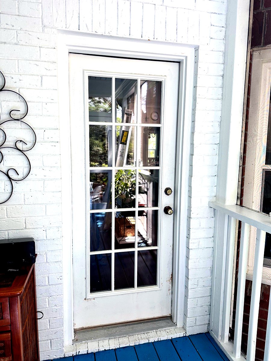 Divided-lite white French entry door set into a white brick wall in Goose Creek, SC