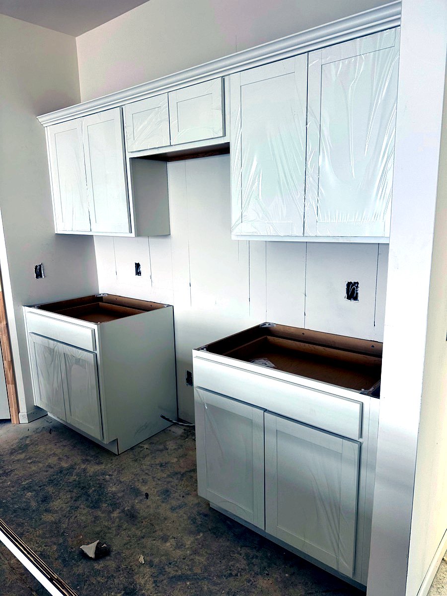 Completed luxury white kitchen cabinets with crown moulding trim in Goose Creek, SC