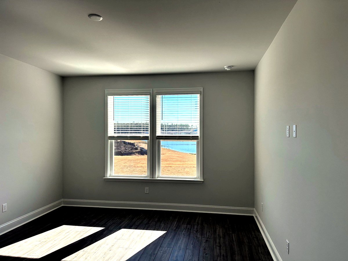 Double-hung premium windows with custom blinds framing a scenic lake view in Goose Creek, SC